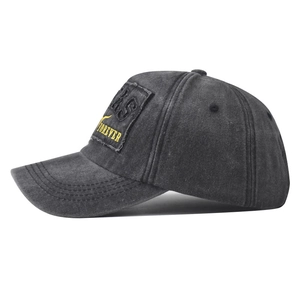 Detail view of washed grey baseball cap featuring heavy embroidery and vintage patch