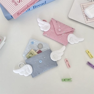 Macro shot of envelope style coin purses with wing accents and star prints in soft colors