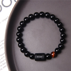 Detail of Virgo beaded bracelet with tiger eye stone and black beads on a tray