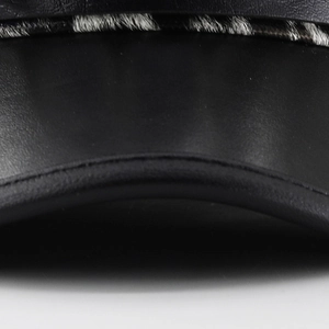 Detailed close-up showing black matte leather stitching and zebra pattern faux fur trim