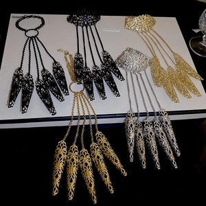 Detailed view of hollow floral finger armor bracelets in gold, silver, and black metal