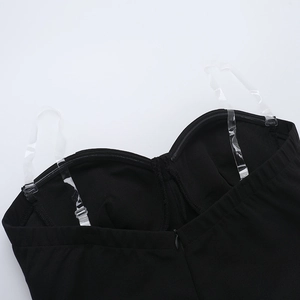 Detailed close-up of the black tube top dress neckline with transparent adjustable straps