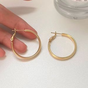 Minimalist high-polish golden hoop earrings featuring a sleek metallic finish for women