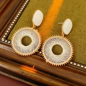 Retro gold woven mesh circle earrings with white oval inlay shown from a 45-degree angle