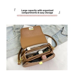 Détail de l'intérieur d'un sac en cuir marron avec compartiments et boucle dorée