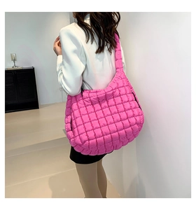 Detail of pink quilted cloud bag featuring soft padded texture and wide shoulder strap