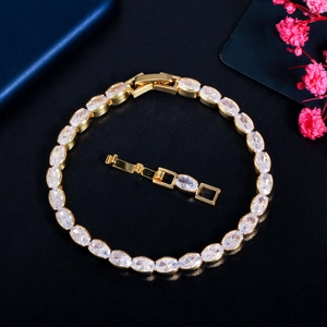 Elegant gold zircon bracelet with oval stones and extender on dark textured backdrop