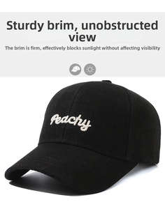 Close-up of Peachy white embroidery on a black cotton twill baseball cap with curved brim