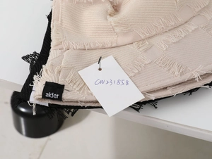 Detailed macro view of woven bucket hats with fringed edges in beige and black colors