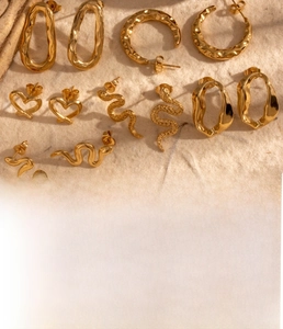 Detailed specs of gold snake and heart earrings in polished titanium steel