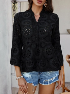 Détail du haut noir en broderie anglaise avec manches 3/4 évasées et encolure en V élégante