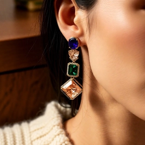 Detail of vintage geometric earrings with colorful crystals worn on model's ear