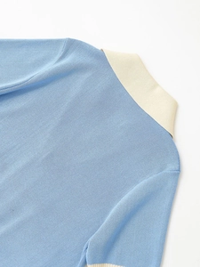 Close-up of light blue knit polo shirt collar with contrasting beige ribbed neck details