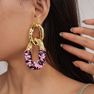 Detail of pink leopard print geometric earring with gold metal link on female model