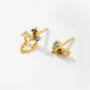 Detail of s925 silver stud earrings with colorful zircons and golden chain tassel