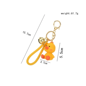 Cute yellow duck resin keychain with knitted texture and wrist strap on white background