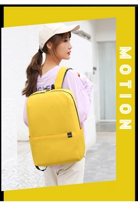 Outdoor model shot of bright yellow fabric backpack featuring front pocket and BOYU logo