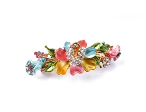 Detail view of colorful enamel flower hair clip with rhinestones and vintage butterfly style
