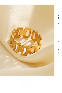 Détail d'une bague ouverte à maillons plaquée or 18 carats sur du tissu de soie