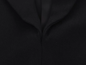 Detailed macro view of the black lace dress lapel stitching and woven plain texture