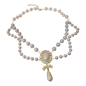 Double-layered pearl necklace with bow accent and teardrop pendant in gold finish