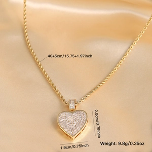 Iced-out brass heart pendant necklace with shimmering white zircons on golden silk background