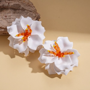 Macro view of white acrylic 3D flower earrings with orange beaded stamens details