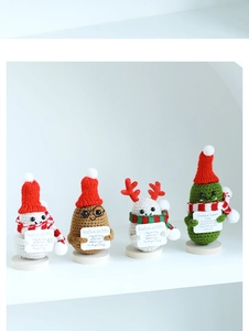Close-up of handmade crochet positive potato and pickle dolls with holiday cards