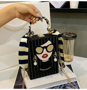 Detail of box clutch with cartoon character applique and silk scarf wrapped handle