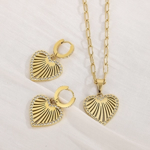 Detail of gold hollow heart necklace and earrings set with micro-pave crystals