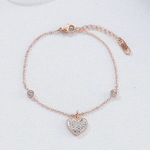 Vista macro di un bracciale a cuore in acciaio inossidabile oro rosa con cristalli