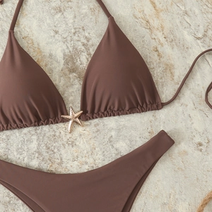 Detailed flat lay of chocolate bikini with a decorative gold starfish pendant