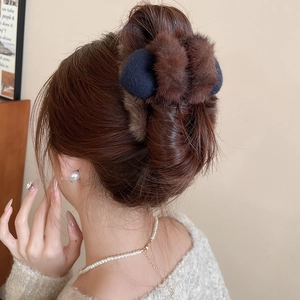 Détail de la pince à cheveux en peluche marron sur modèle avec texture fausse fourrure