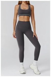 Detailed view of grey yoga set featuring high-waist leggings with white piping accents