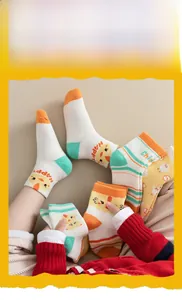 Close-up of cotton knit baby socks with colorful stripes and cute cartoon chick patterns