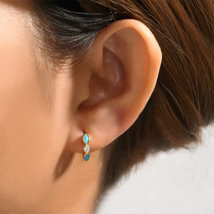 Close-up of gold hoop earrings with marquise turquoise stones and round clear zircon
