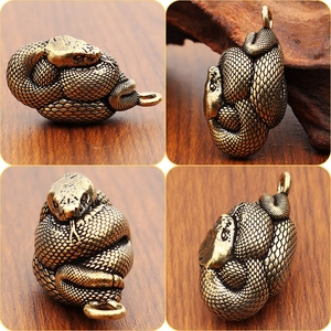 Dettaglio del ciondolo a serpente in ottone vintage con squame e texture incise