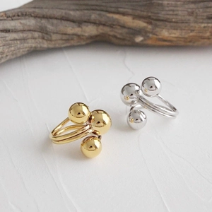 Detail of minimalist irregular sphere rings in gold and silver finish with twin-band design
