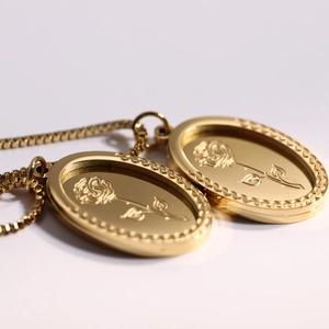 Vintage gold oval stainless steel necklace featuring embossed rose pendant on box chain