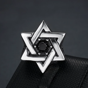Macro shot of polished silver hexagram ring with a centered black stone on leather