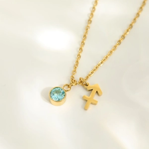 Macro detail of gold Sagittarius zodiac bracelet with light blue zircon on silk