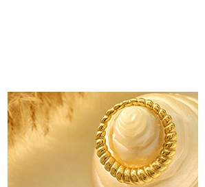 Detailed view of gold twisted rope ring on shell tray with aesthetic feather accents