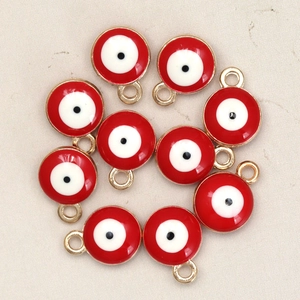 Macro detail of red evil eye alloy pendants with gold plating for DIY jewelry making