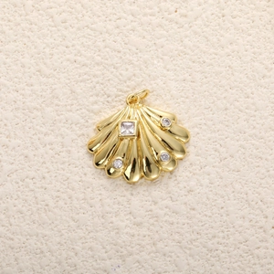 Macro detail of a 14k gold plated shell pendant with sparkling cubic zirconia stones