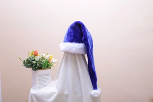 Detail of dark blue plush Christmas hat with white faux rabbit fur trim on a display stand