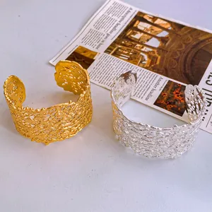 Minimalist glossy hollow open bangle in gold and silver with artistic lava mesh texture