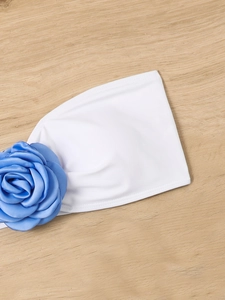 Detailed view of large blue satin rose attached to a white elastic bikini band