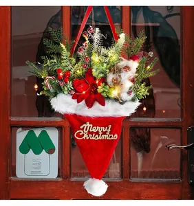 Illuminated Christmas hat door hanging with pine needles and festive red berries decorations