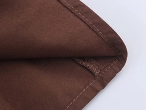 Vue détaillée de l'ourlet à aiguille unique sur une robe midi de couleur marron foncé