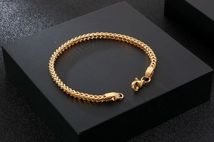 Detailed view of golden stainless steel curb chain bracelet with classic lobster clasp